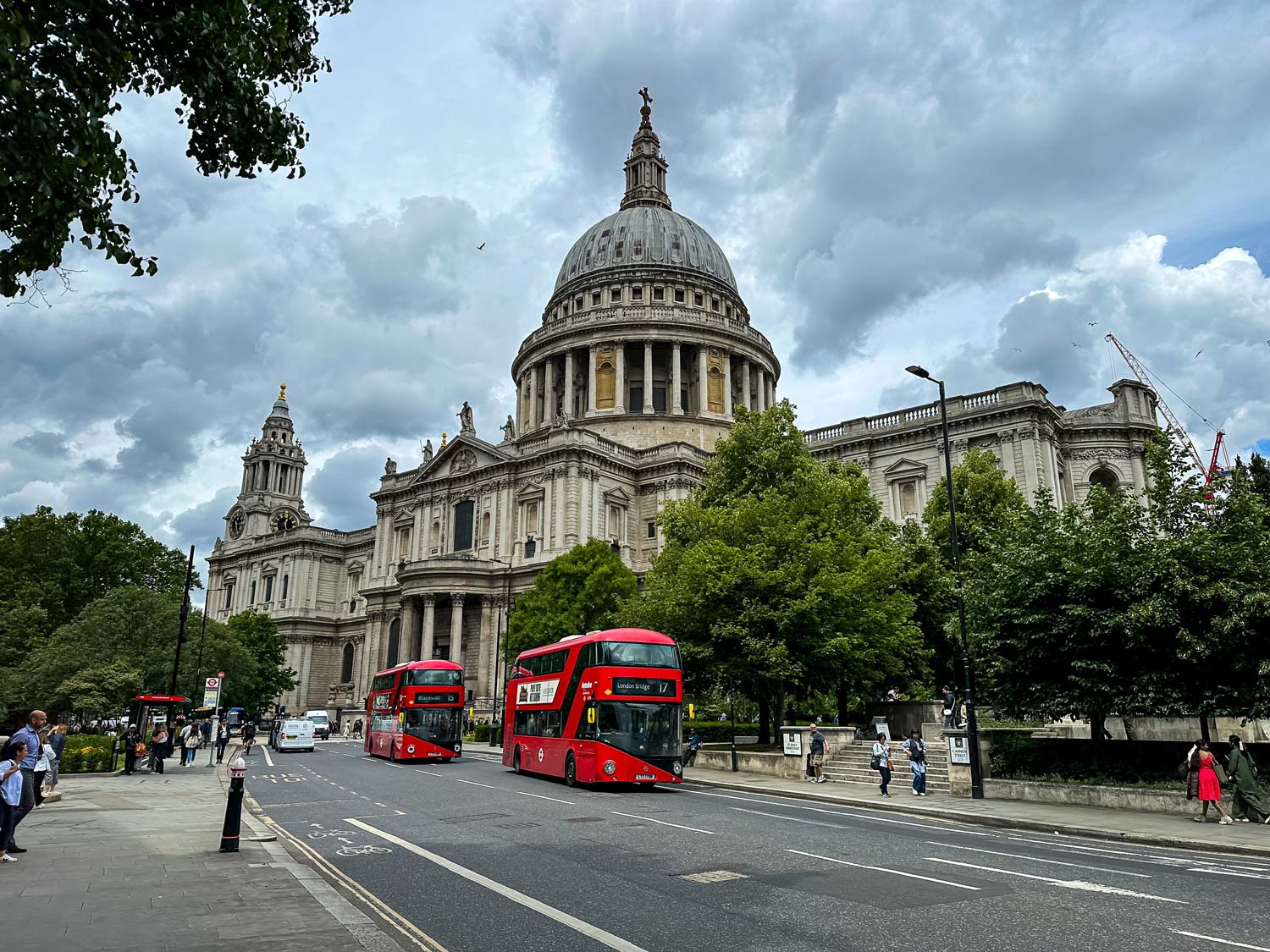 St Paul's Cathedral and London buses on a city street in London.